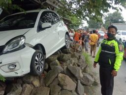 Hilang Kendali, Honda Brio Hantam Batu Bekas Bangunan Warung