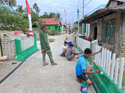 Semangat Gotong Royong Satgas TMMD bersama masyarakat Warnai Pengecatan Pagar di Desa Umbele Lama