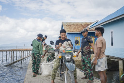 Satgas TMMD Angkut Material Pasir dengan Sepeda Motor untuk Pekerjaan Rabat Beton Jalan