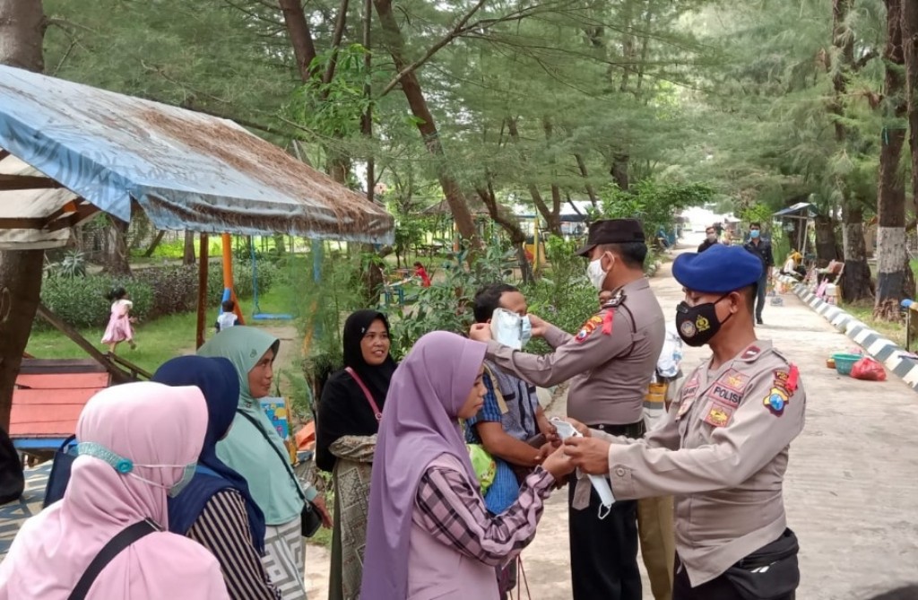 Antisipasi Covid 19, Polres Sampang Bagikan Masker pada Pengunjung Pantai Camplong