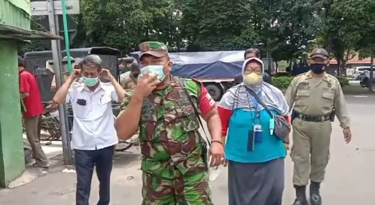Babinsa Perak Utara Woro-woro dan Bagikan Masker di Pasar Kilometer.