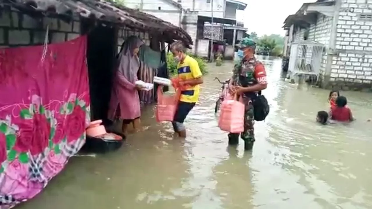 Menyusuri Banjir Di Benjeng, Serda Untung Bagikan Nasi Kotak Kepada Warga Binaan