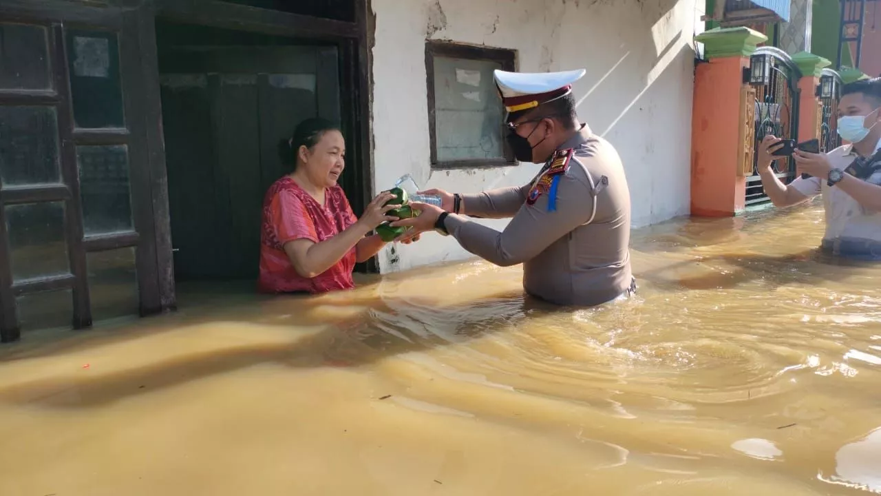 Satlantas kabupaten Sampang Bagi Nasi Bungkus ke Warga Korban Banjir