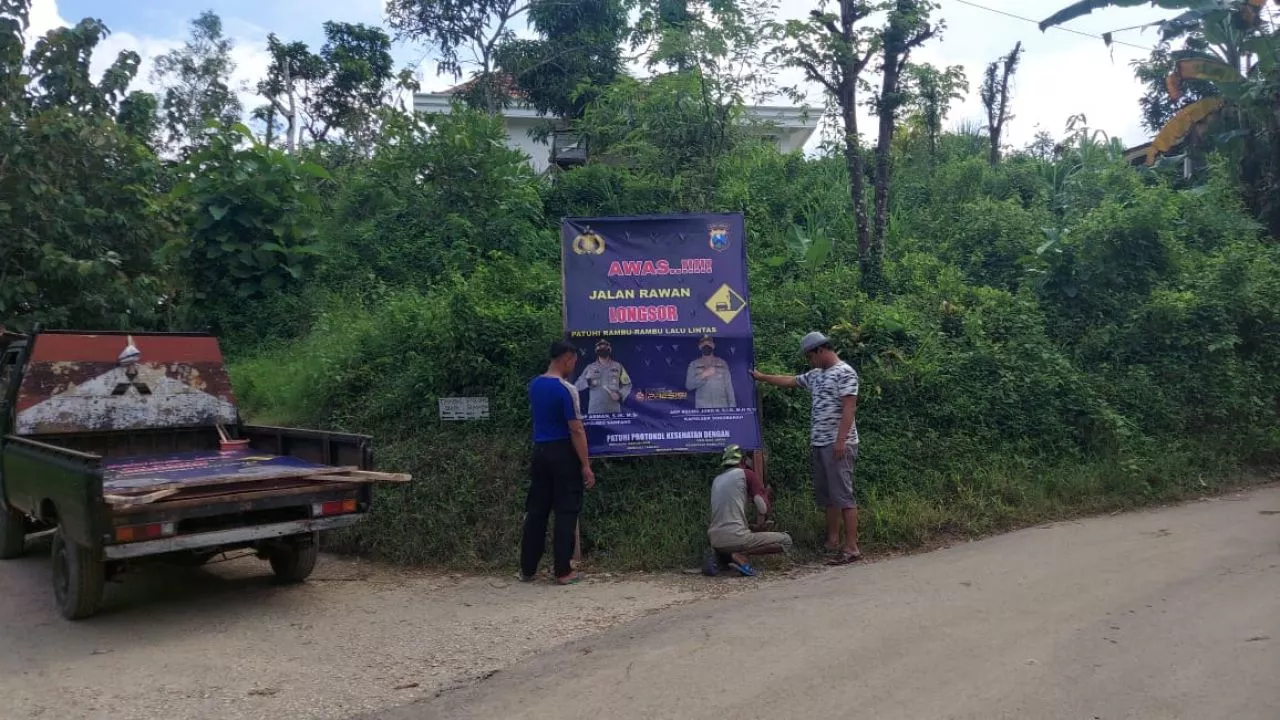 Polsek Sokobanah Pasang Papan Himbauan Awas Jalan Longsor di Jalan Desa Bira Tengah