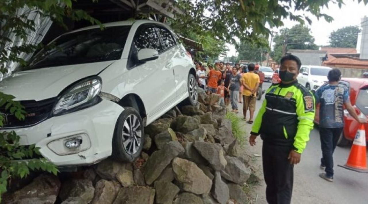 Hilang Kendali, Honda Brio Hantam Batu Bekas Bangunan Warung