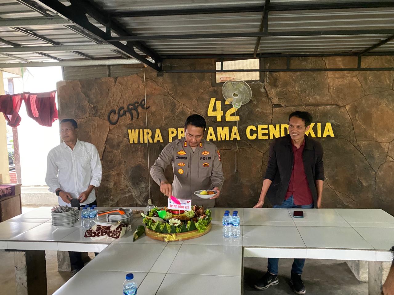 Caption. Kepala Kepolisian Sektor Tumpang Resor Malang AKP Achmad Zainuddin saat memotong dalam memperingati HPN tahun 2024 di Mapolsek Tumpang