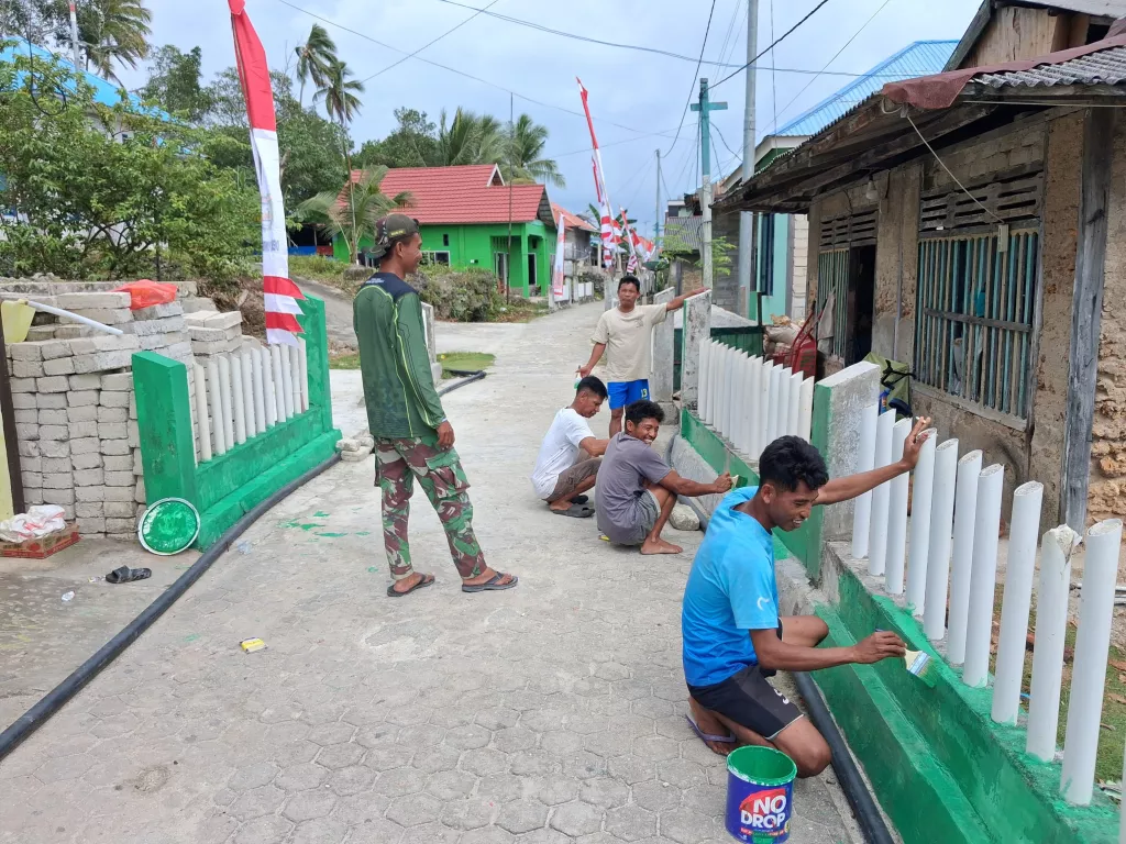 Semangat Gotong Royong Satgas TMMD bersama masyarakat Warnai Pengecatan Pagar di Desa Umbele Lama
