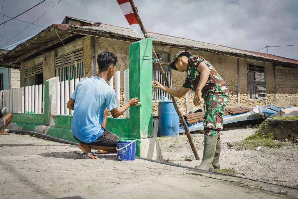 Kebersamaan Satgas TMMD dan Warga Warnai Pengecatan Pagar di Desa Umbele Lama
