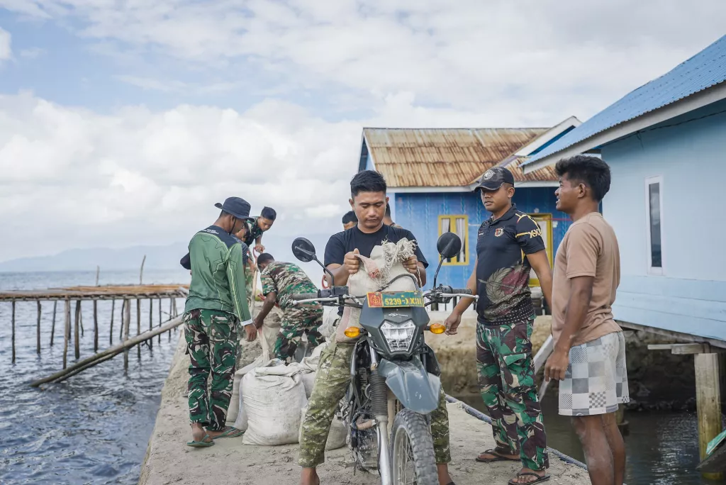 Satgas TMMD Angkut Material Pasir dengan Sepeda Motor untuk Pekerjaan Rabat Beton Jalan