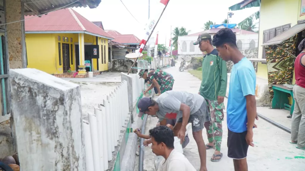 Satgas TMMD Bersama Masyarakat Laksanakan Pengecatan Pagar, Percantik Desa Umbele