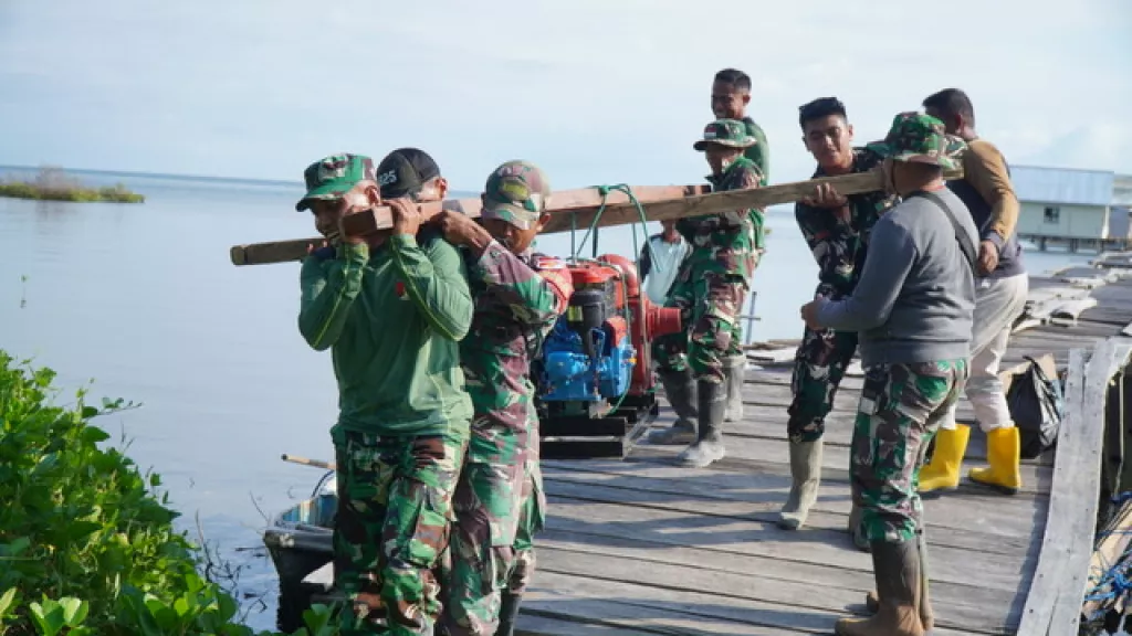 Satgas TMMD Bersama Masyarakat Gotong Royong Memikul Mesin Air untuk Program Manunggal Air
