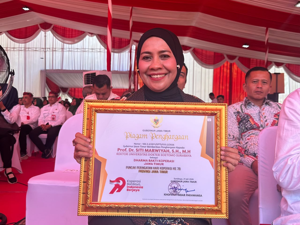 Prof. Dr. Siti Marwiyah, S.H., M.H., menunjukkan Piagam Penghargaan Dharma Bakti Koperasi Jawa Timur yang diterimanya dari Gubernur Jawa Timur.